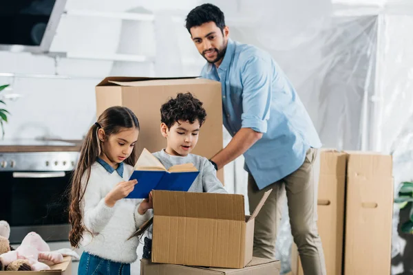 Söta Barn Läsa Bok Medan Far Håller Låda Nya Hem — Stockfoto