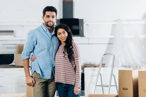 Cheerful Latin Couple Embracing Smiling Boxes New Home — Stock Photo, Image