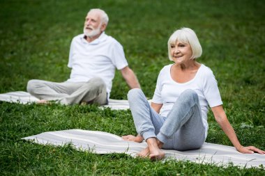 üst düzey çift rahatlama meditasyon yoga paspaslar üzerine otururken poz veriyor 
