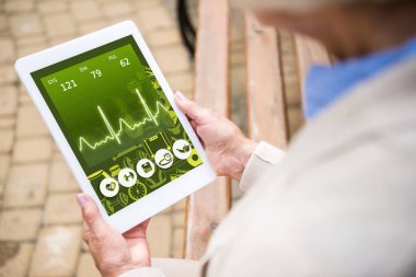 seçici odak üst düzey kadın kalp atışı oranı üstünde perde ile dijital tablet kullanma