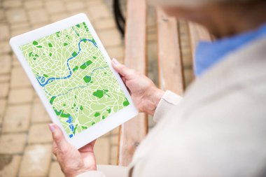 seçici odak üst düzey kadın ile harita üzerinde ekran dijital tablet kullanma