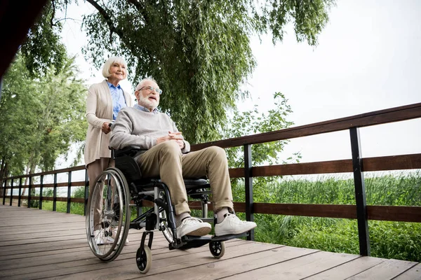 Trevlig Äldre Kvinna Bär Man Rullstol Medan Promenader Parken — Stockfoto