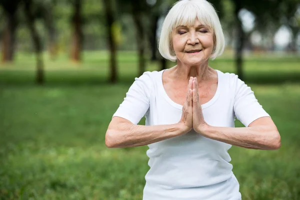 Senior Kvinna Meditation Sukhasana Posera Med Knäppta Händer — Stockfoto