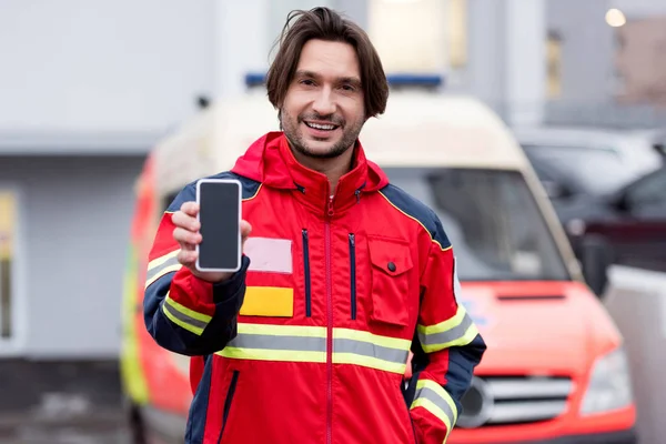 Paramédico Sorridente Uniforme Vermelho Segurando Smartphone Com Tela Branco — Fotografia de Stock