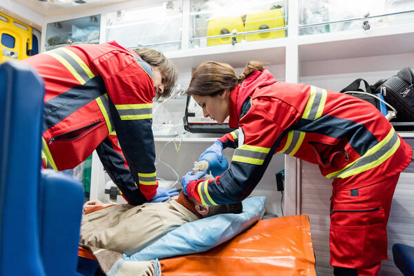 Paramedics doing cardiopulmonary resuscitation in ambulance car