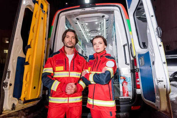 İlk yardım ekibi kırmızılı ambulans araba önünde üniforma