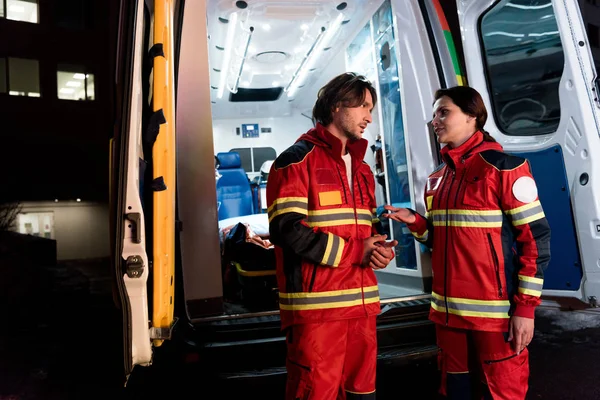Paramédicos Uniforme Rojo Hablando Cerca Coche Ambulancia — Foto de Stock