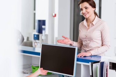 Klinikte hemşire hasta konuşurken gülümseyen