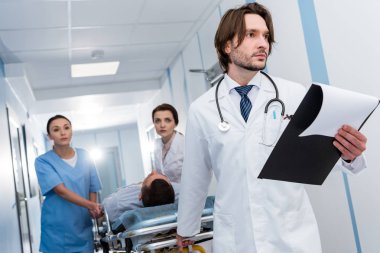 Doktorlar üniformalı hastayı sedyeye taşıma
