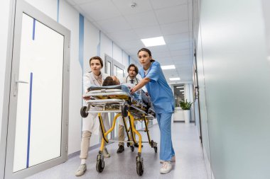 Endişeli doktor ve hemşire sedye üzerinde bilinçsiz hasta taşıma