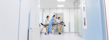 Doktor ve hemşire sedye üzerinde bilinçsiz hasta taşıma konsantre 