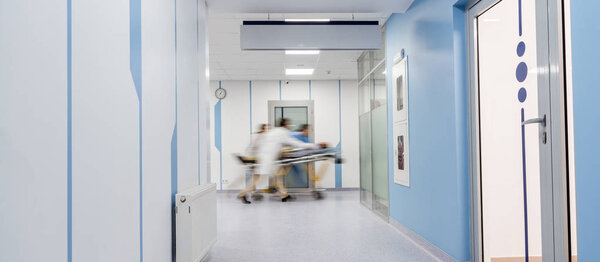 Группа врачей, перевозящих пациента на каталке
