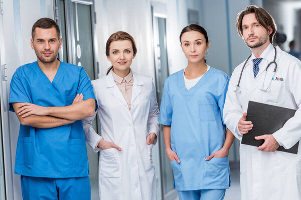 Doctors and nurses in blue uniform looking at camera