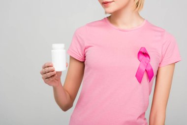 kırpılan pembe t-shirt ile meme kanseri bilinçlendirme şerit şişe gri izole ilaçlarla tutan kız görünümünü 