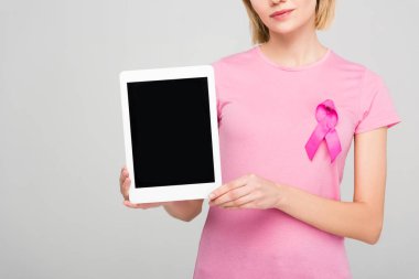 kırpılan tablet ile boş perde, gri izole tutan Meme Kanseri Bilinçlendirme şerit pembe tişört kız görünümünü