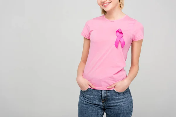 裁剪的看法 微笑的年轻女子在粉红色的 T恤与乳腺癌意识丝带 隔离在灰色 — 图库照片