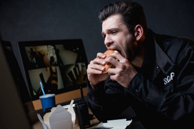 tek tip hamburger yeme ve bilgisayar monitörü arıyor koru 