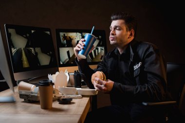 Hamburger yeme, kağıt bardak tutan bağlayıp, bilgisayar monitörü seyir 