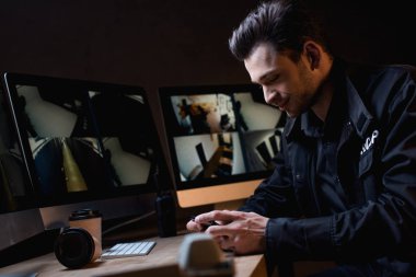 İşyerinde smartphone kullanarak Üniformalı Muhafız gülümseyen 