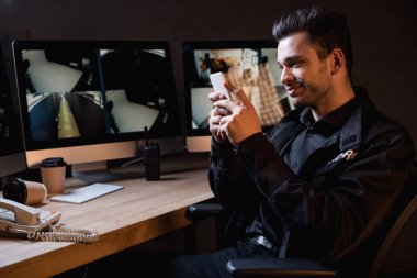 çalışma alanı smartphone kullanarak Üniformalı Muhafız gülümseyen