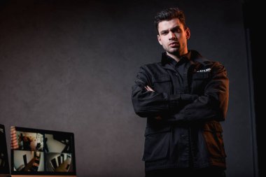 Kameraya bakarak çapraz kolları olan üniformalı ciddi nöbet