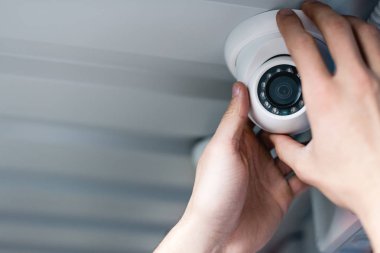 cropped view of man setting up security camera clipart