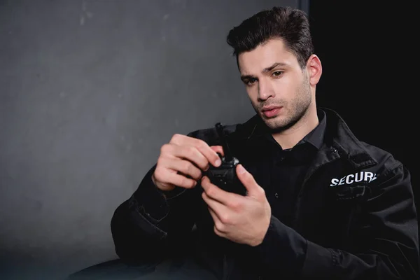 Guapo Guardia Uniforme Sosteniendo Walkie Talkie Mirando Hacia Otro Lado — Foto de Stock