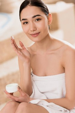 Spa'da kozmetik krem uygulamak havlu güzel Asyalı kadın 