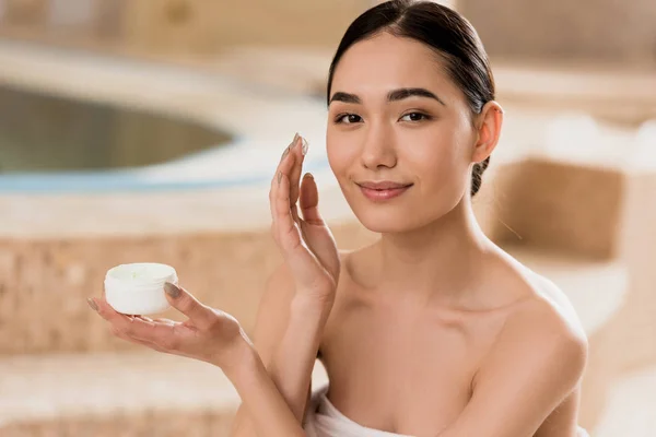 Hermosa Mujer Asiática Aplicando Crema Cosmética Mirando Cámara — Foto de Stock