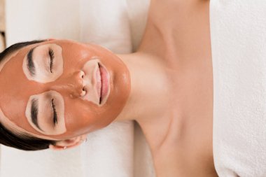 güzel kadının kil maskesi Spa'da kapalı gözlerle yüzündeki yalan Üstten Görünüm 