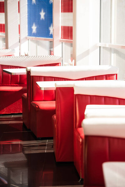 interior of cafe with red sofas and white tables 