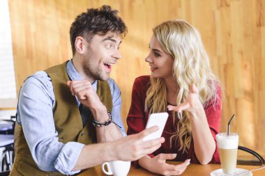 yakışıklı erkek ve smartphone kullanarak ve café'de konuşmak güzel kadın 