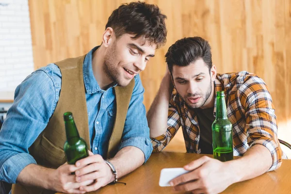 Stiliga Män Hålla Glasflaskor Och Med Smartphone — Stockfoto