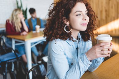seçici odak kağıt Kupası uzağa café'de seyir tutan güzel kadın 