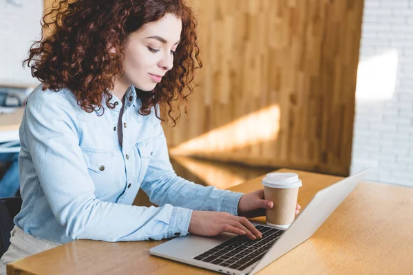 Hermosa Mujer Sosteniendo Taza Papel Uso Ordenador Portátil Cafetería — Foto de Stock