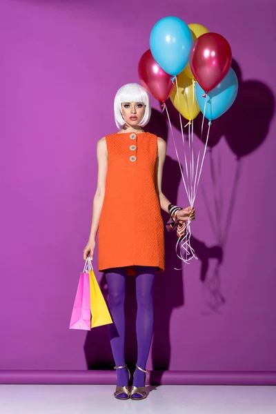 Trendiges Mädchen Weißer Perücke Mit Luftballons Und Einkaufstaschen Auf Lila — Stockfoto