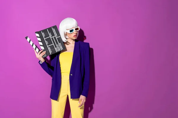 Elegante Donna Occhiali Tenendo Clapperboard Guardando Lontano Sfondo Viola — Foto Stock
