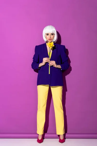 Серьёзная Девушка Синей Куртке Держит Желтый Цветок Фиолетовом Фоне — стоковое фото
