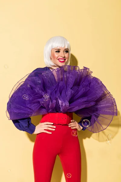 Laughing Young Woman Wig Standing Arms Akimbo Yellow Background — Stock Photo, Image