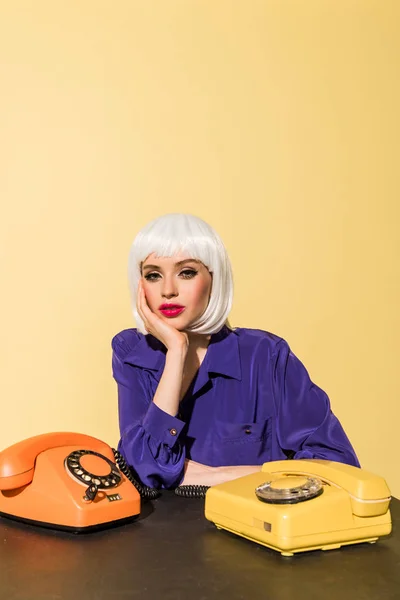 Curious Woman Wig Posing Old Telephones Isolated Yellow — Stock Photo, Image