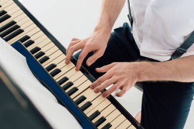 selective focus of pianist in white shirt playing piano  clipart