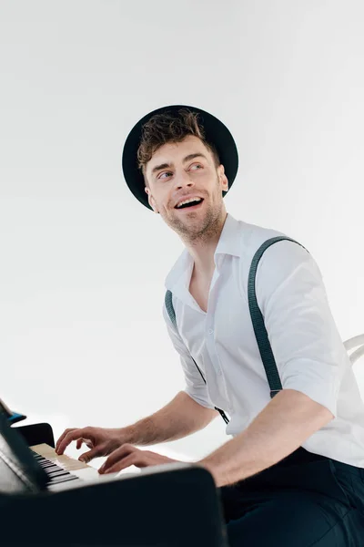 陽気な白いシャツと黒い帽子のピアノを弾くピアニスト — ストック写真