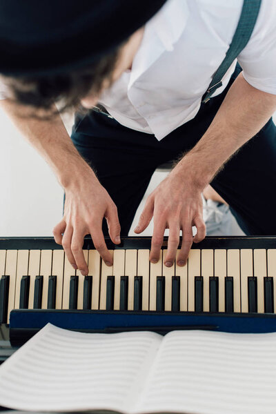 селективный фокус пианиста в белой рубашке, играющего на пианино
 