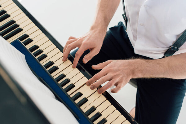 селективный фокус пианиста в белой рубашке, играющего на пианино
 