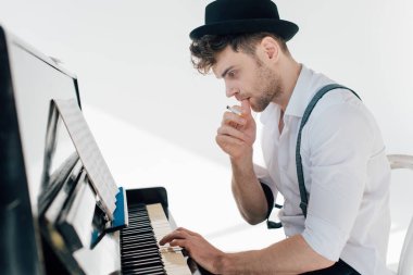 düşünceli müzisyen piyanoda otururken müzik bestelemek 