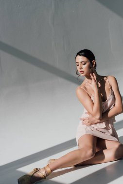 güneş ışığı altında oturan pembe elbiseli çekici genç balerin