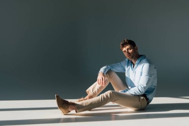 neşeli yakışıklı adam koltukta güneş ışığı, dinlenme 