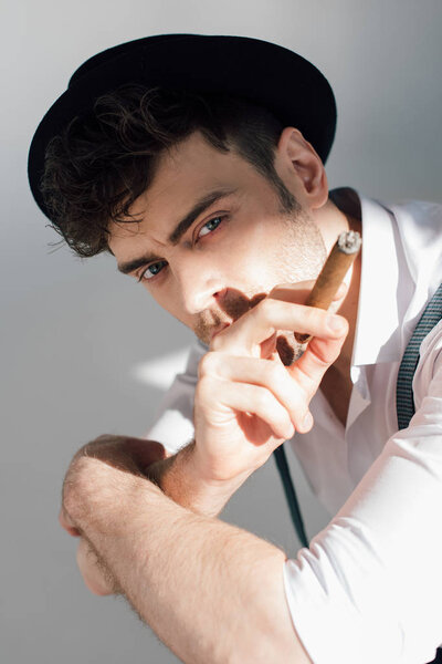 serious handsome man with cigar looking at camera