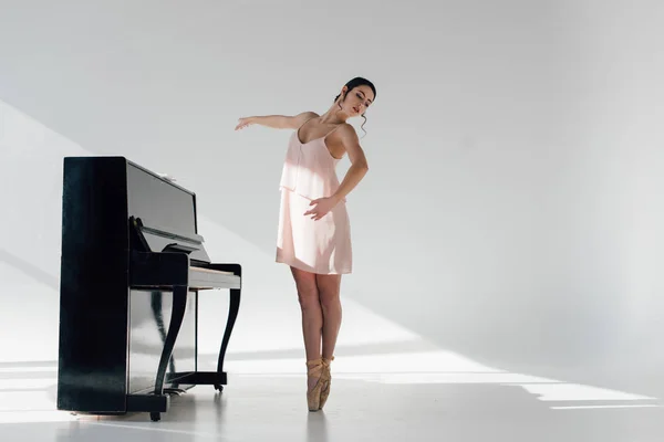 Молодая Балерина Танцует Солнце Возле Черного Фортепиано — стоковое фото