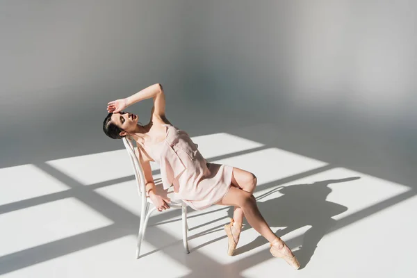 美丽的年轻芭蕾舞演员坐在白色的椅子上 在阳光下 — 图库照片